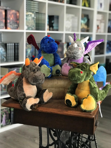 Das Bild zeigt vier Plüschdrachen in verschiedenen Farben.